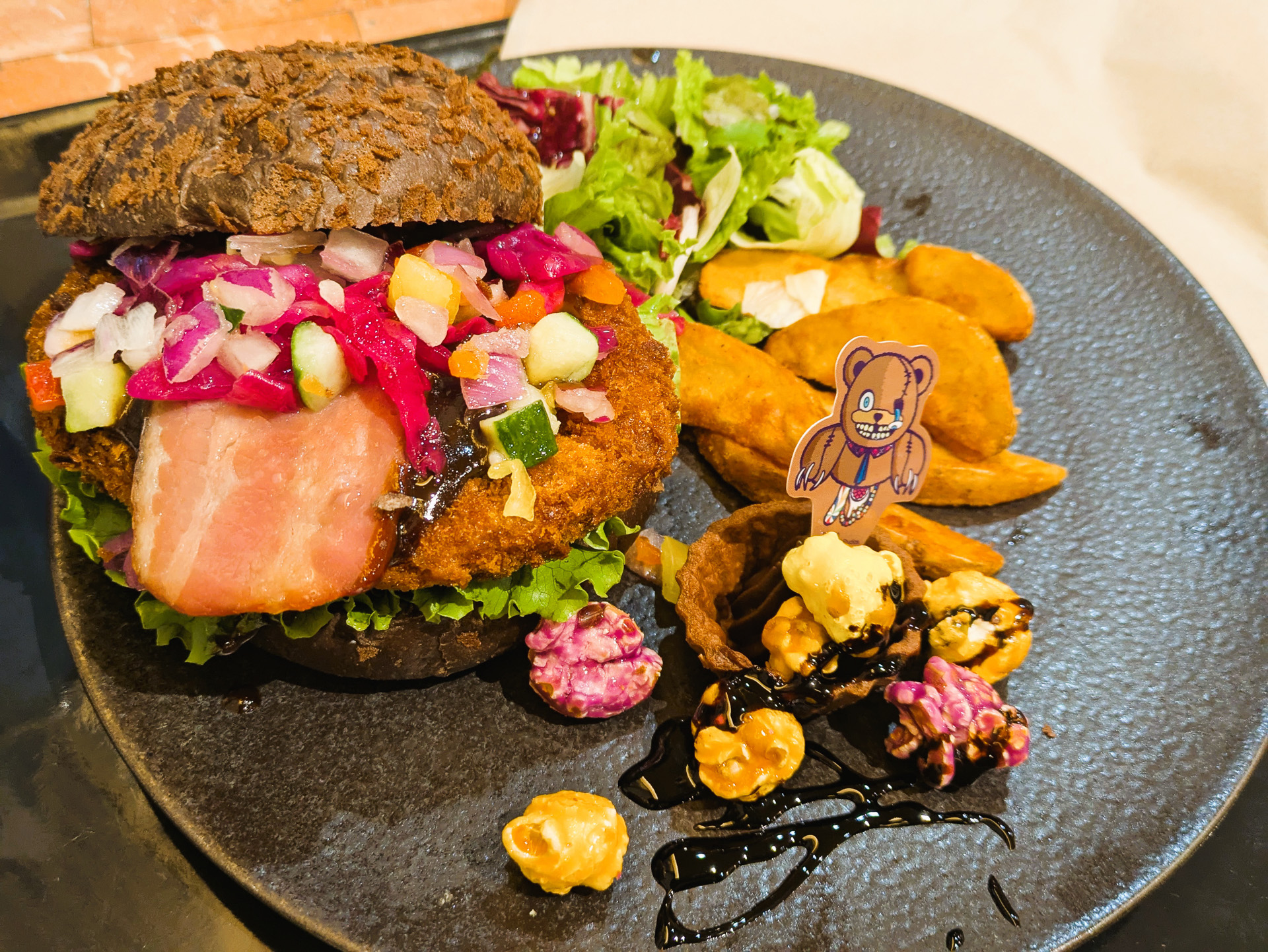 筆者が試食したのはハミクマ。散らばったポップコーンでハミクマのお腹から出ているあんなものやこんなものを表現。チキンカツはなかなか分厚く、野菜もしっかり入っているのでかなり食べでがある