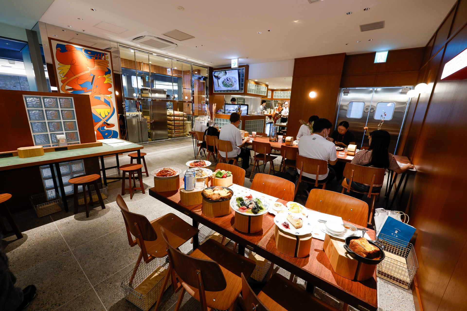 「TOKYO PASTA STATION」のテーブル席。正面の奥にあるガラス張りのスペースがオープンキッチン。なお、モーニングメニューもあるとのこと