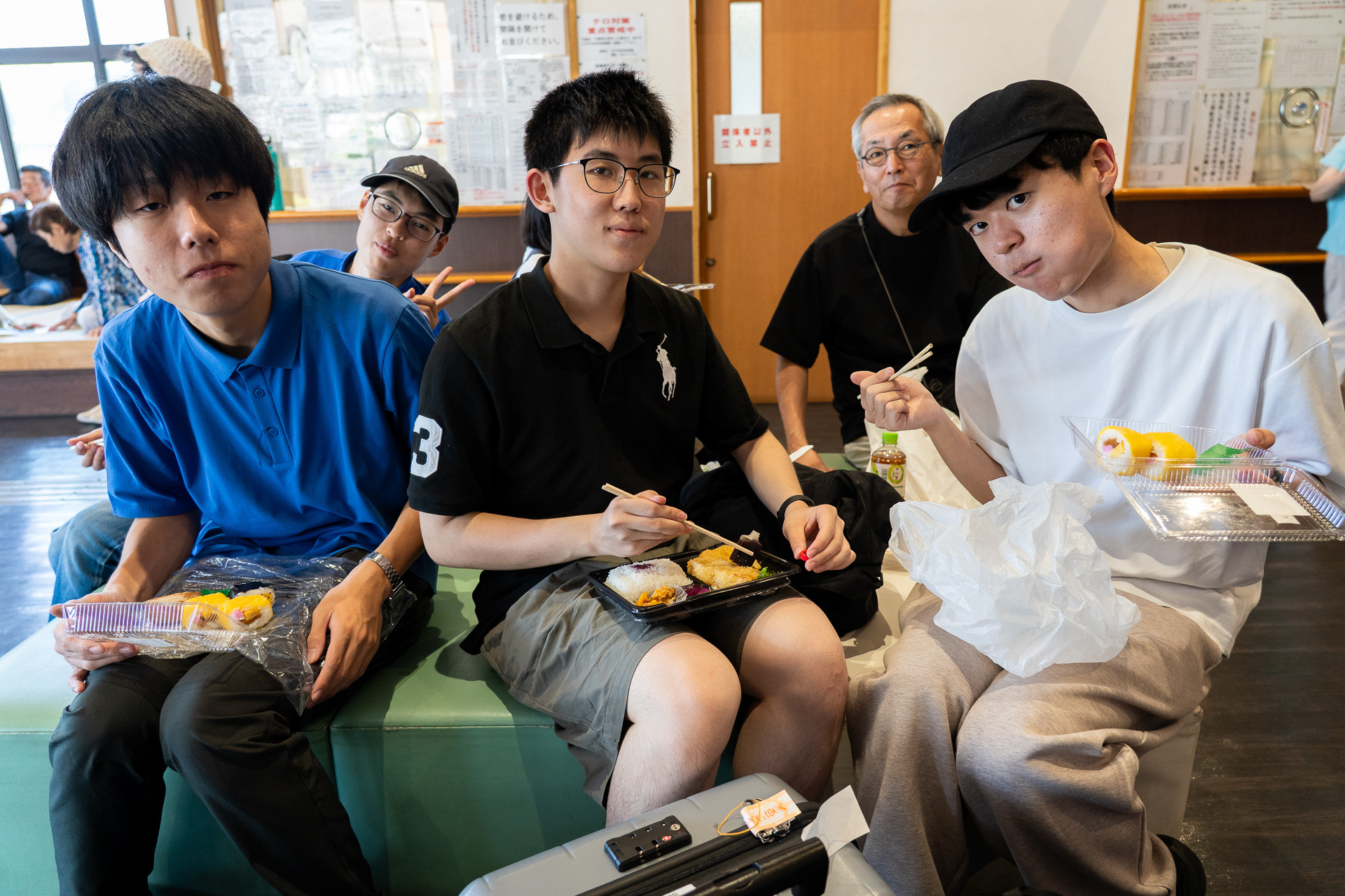 移動中のリラックスタイム。土井先生と一緒にお弁当を食べながら雑談する子供たち