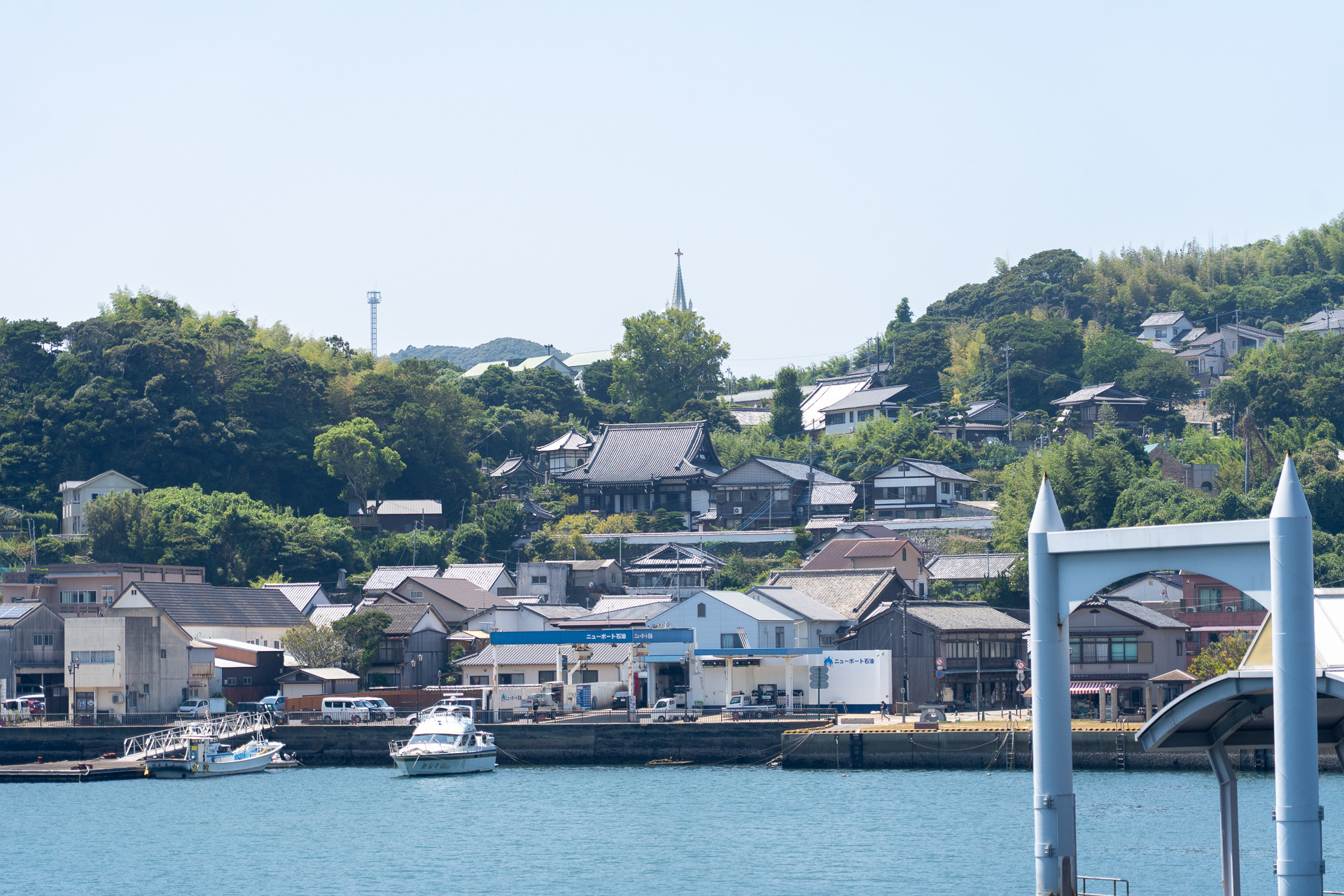 お寺の屋根の向こうに教会の十字架がのぞく平戸独特の街並みが遠ざかる