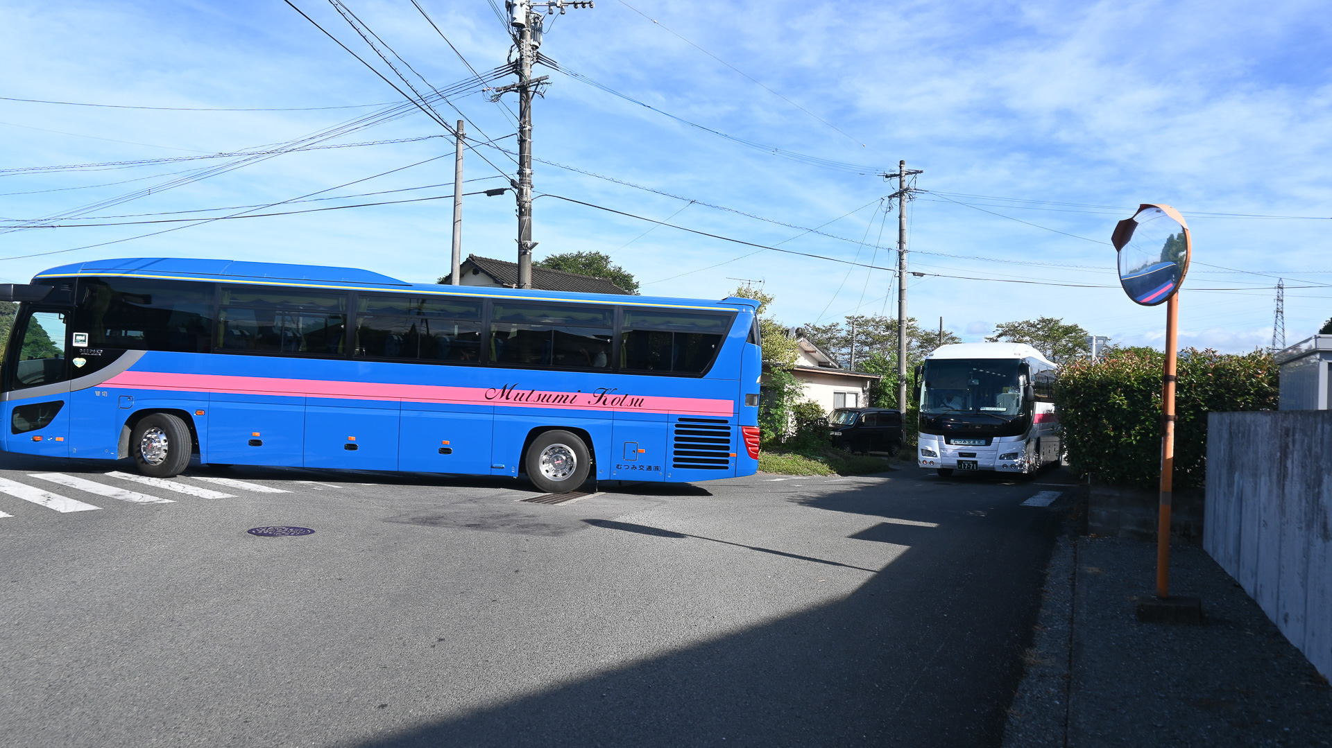 肥後西村駅の細い路地を、次々と出発する代行バス