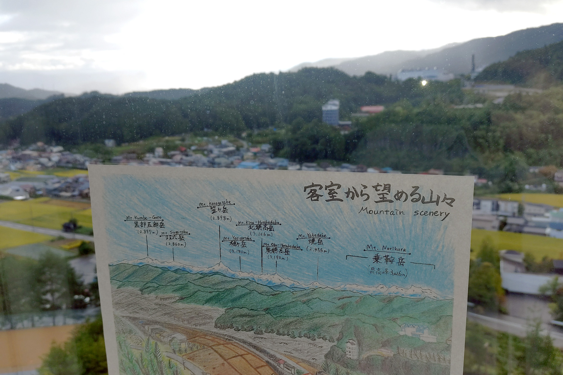 テーブルに置かれていた眺望の説明を窓に当ててみた。晴れた日には日本百名山の山々が見えるそう
