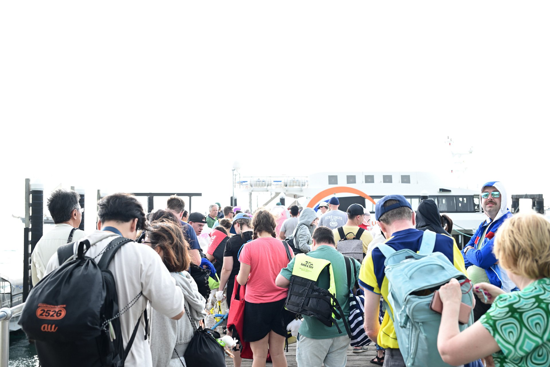 沖合いに投錨していた船が桟橋に戻ってくると、島を楽しんだ参加者が次々と船に乗り込む