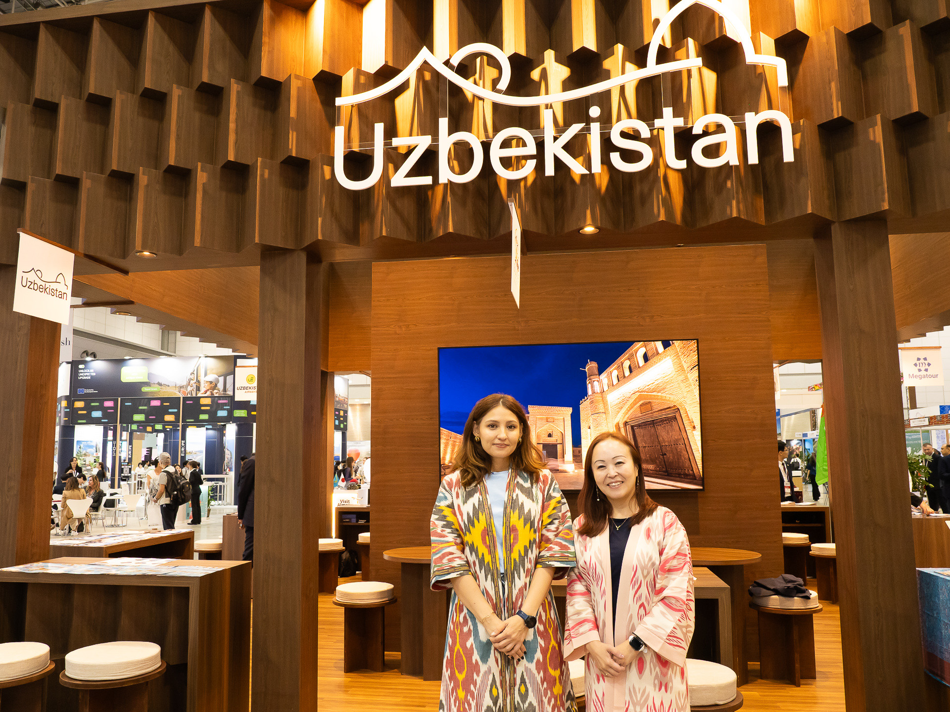 ウズベキスタンの「Tourism Committee of Uzbekistan」ブースの女性スタッフは、「チャパン」というカラフルなデザインの絣のような民族衣装で出迎える