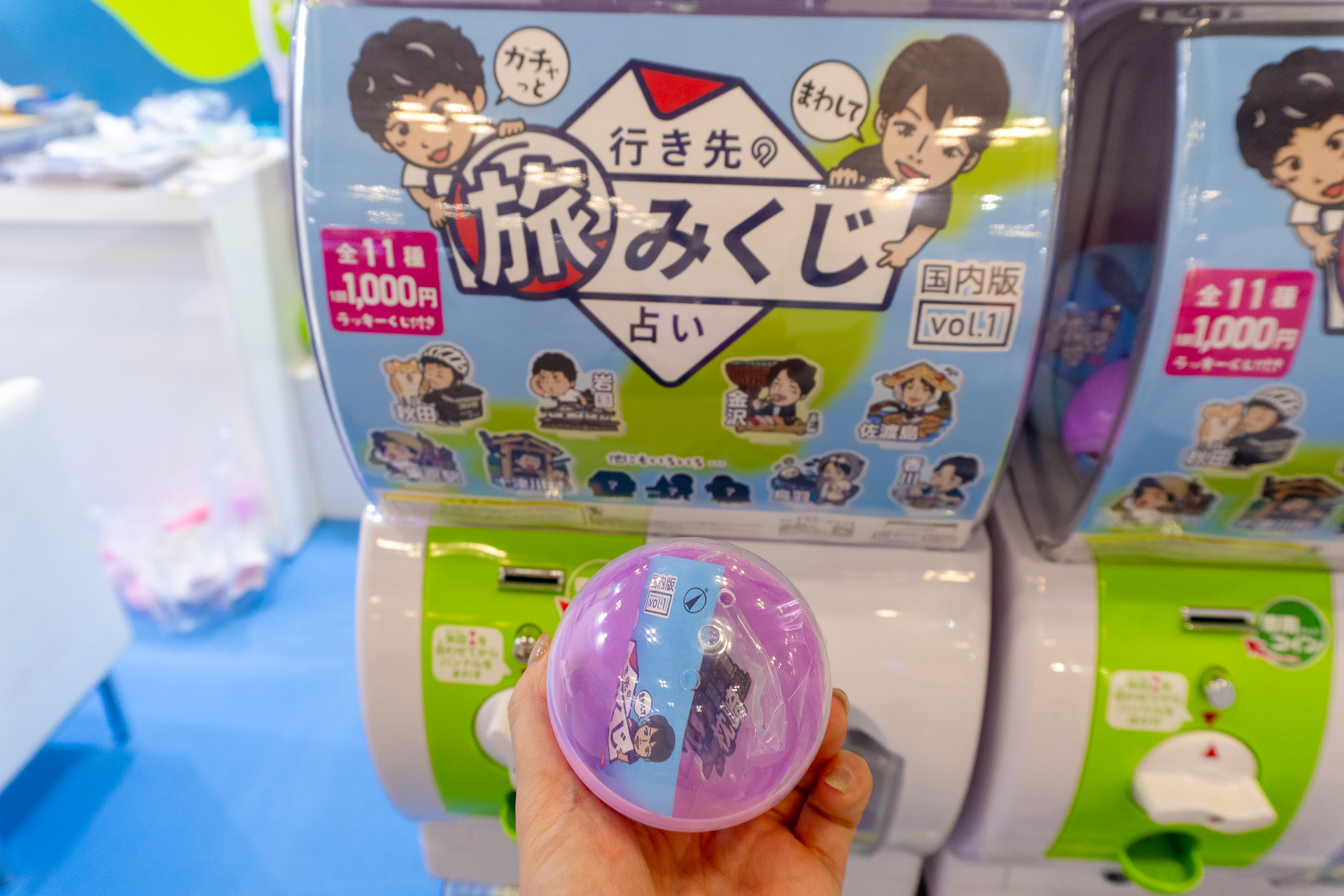 カプセルの中身は、次の旅先を占ってくれる限定アクスタ（シークレット含む全11種のうち1個）と、旅行やカタログギフトが当たる旅みくじ1枚入り