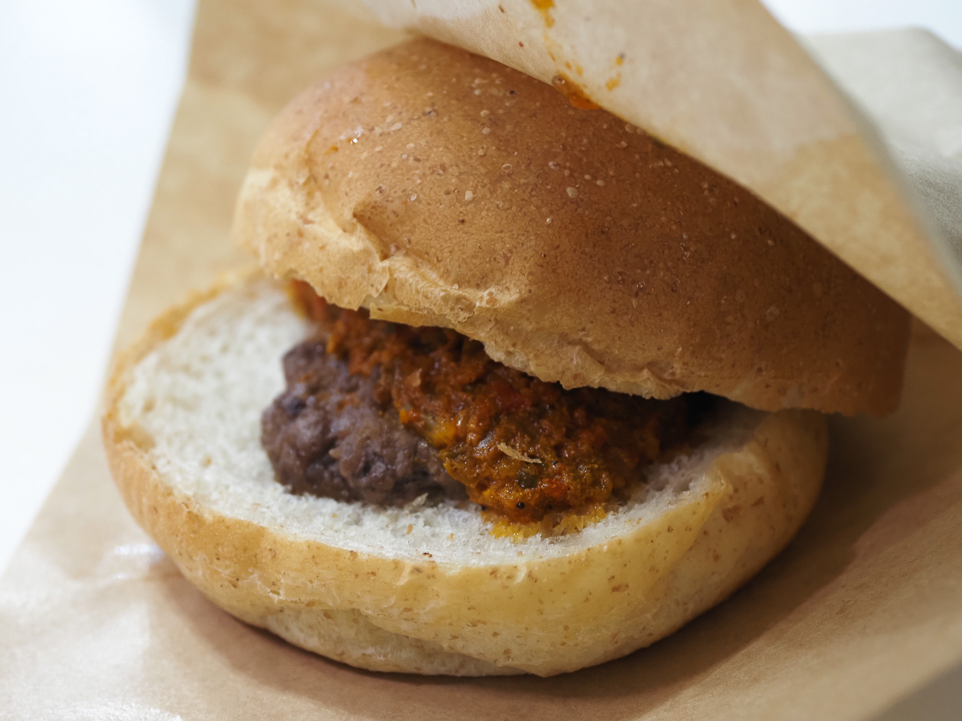 チャモロディナンシェバーガーを食べてみた。ビーフ100％のシッカリ肉に刻んだ野菜のソースがかかっている