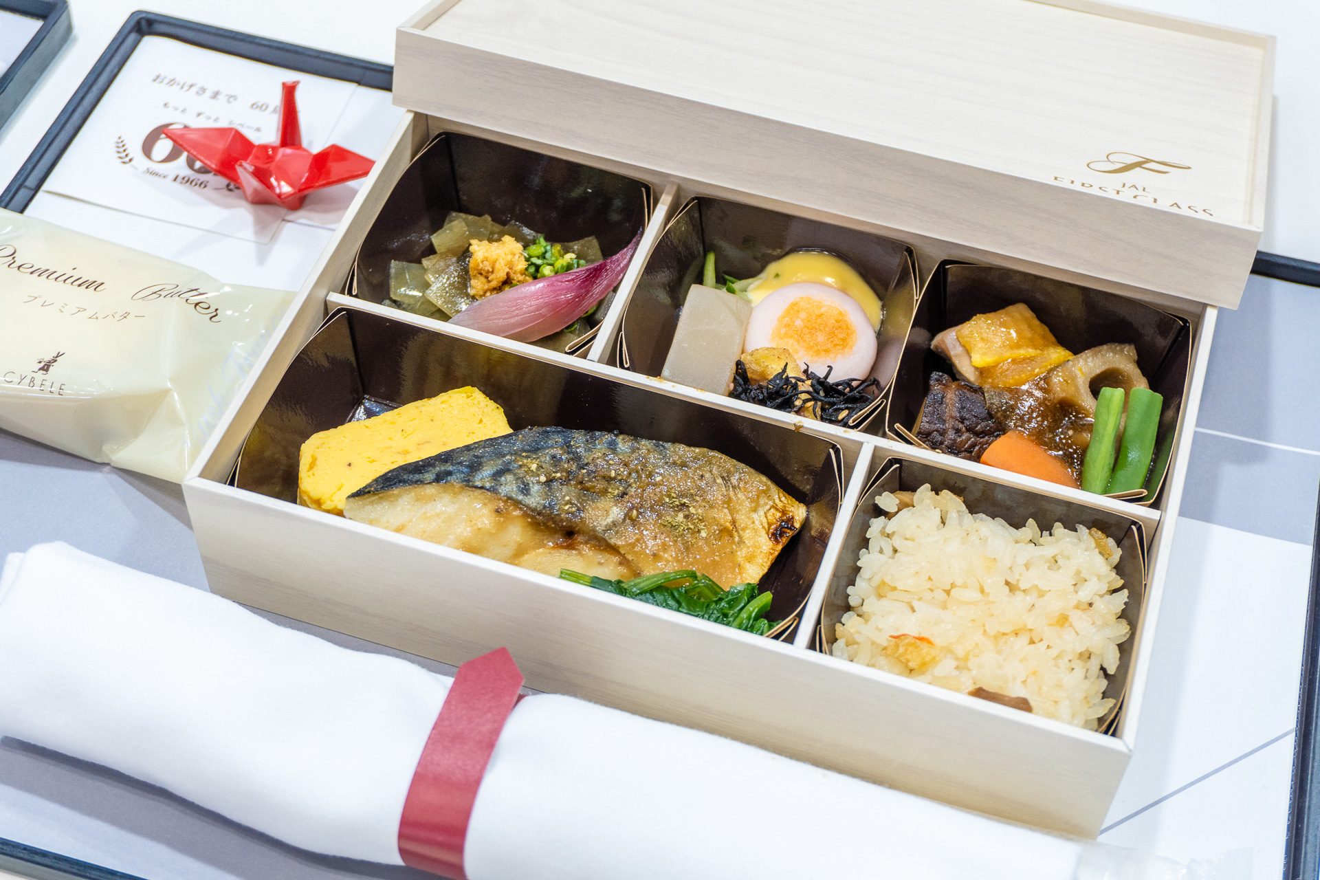 国内線ファーストクラスの新しくなった機内食を展示。羽田～伊丹などの短距離路線はお弁当スタイル（左）、羽田～那覇などの長距離路線はトレーセット（右）で提供