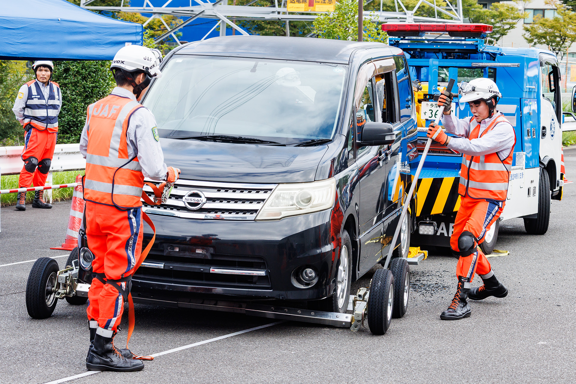 タイヤの両側に車輪を配置し、タイヤの前後をバーで固定。その後、左右それぞれの車輪を操作してタイヤを持ち上げる