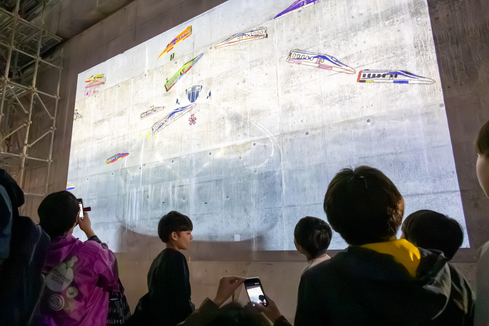 思い思いに着色したリニアの塗り絵を壁面に投影していた