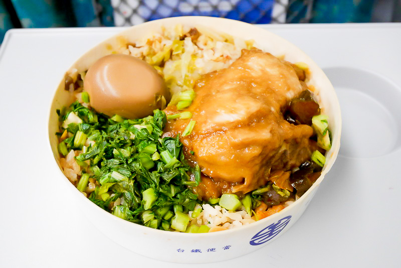 炊き込みご飯の上に、たれに漬け込んだ排骨、味付けゆで卵、からし菜の煮物などがのせられています