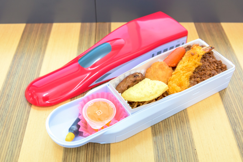 そぼろご飯に海老フライ、ウインナー、ナゲット、ハンバーグ、焼きそば、卵焼き、デザートにゼリーが付いています