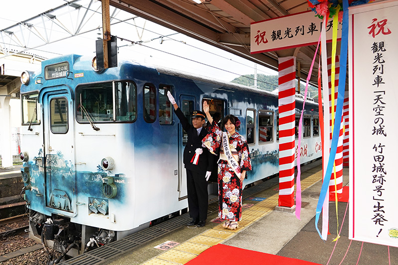 出発合図をする西日本旅客鉄道 城崎温泉駅長 岩本昭信氏と城崎温泉観光大使