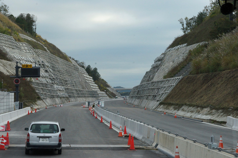 切土崩落現場。切土部分を覆うコンクリートと地中の硬い地層をアンカーで繋ぐ対策工事が実施された。表面にある十字の形状部分にアンカーが埋め込まれている
