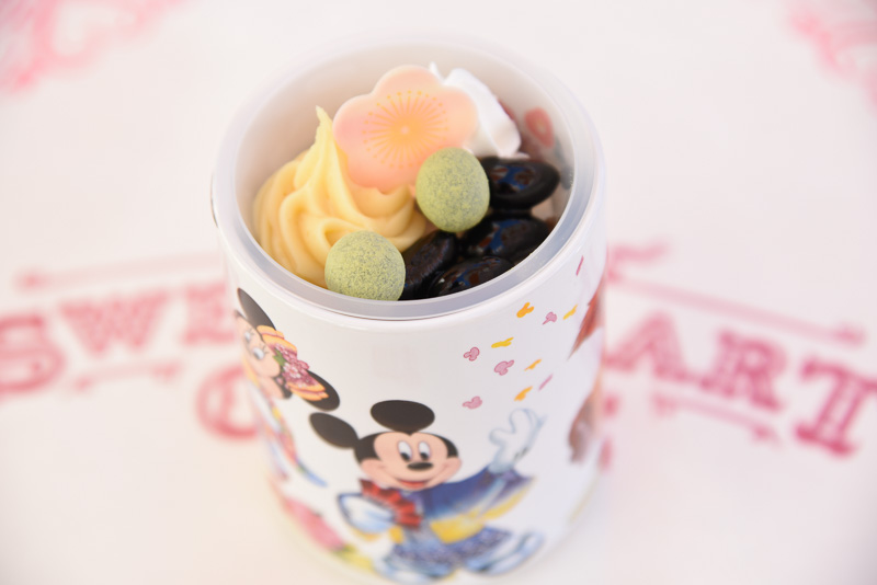 黒豆に梅モチーフのホワイトチョコ、マロンクリームなどが載ったセサミベースのムース。東京ディズニーランドと東京ディズニーシーで購入できる「黒豆＆セサミムース、スーベニアカップ付き」（720円）