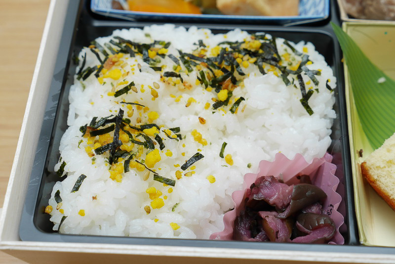 主食のご飯には、ふりかけがかけられています。横にはきゅうりの漬け物も添えられていて、まさに弁当といった雰囲気