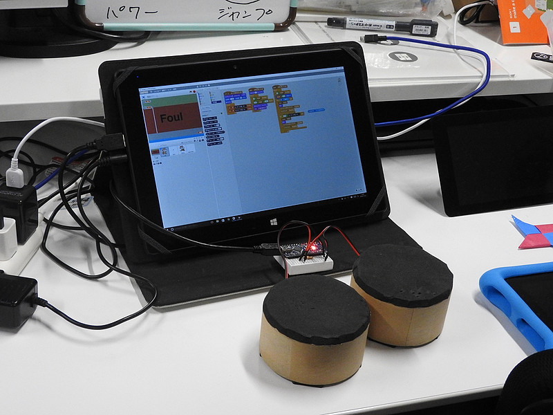 “CoderDojo”が展示していた「Scratch」と外部センサーの連携例。左のタイコを手で叩いて加速し、右のタイコを叩いてジャンプする