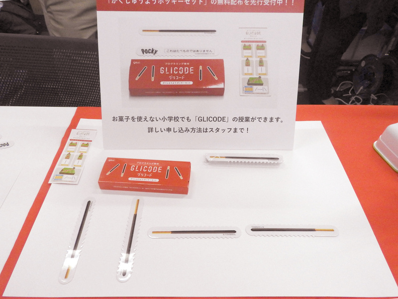 江崎グリコ（株）が展示・デモしていた「GLICODE」。ポッキーを並べてプログラミング学習ができるというユニークな教材だ。本物のお菓子を使えない小学校でも、ポッキーのカードを使って学習できる