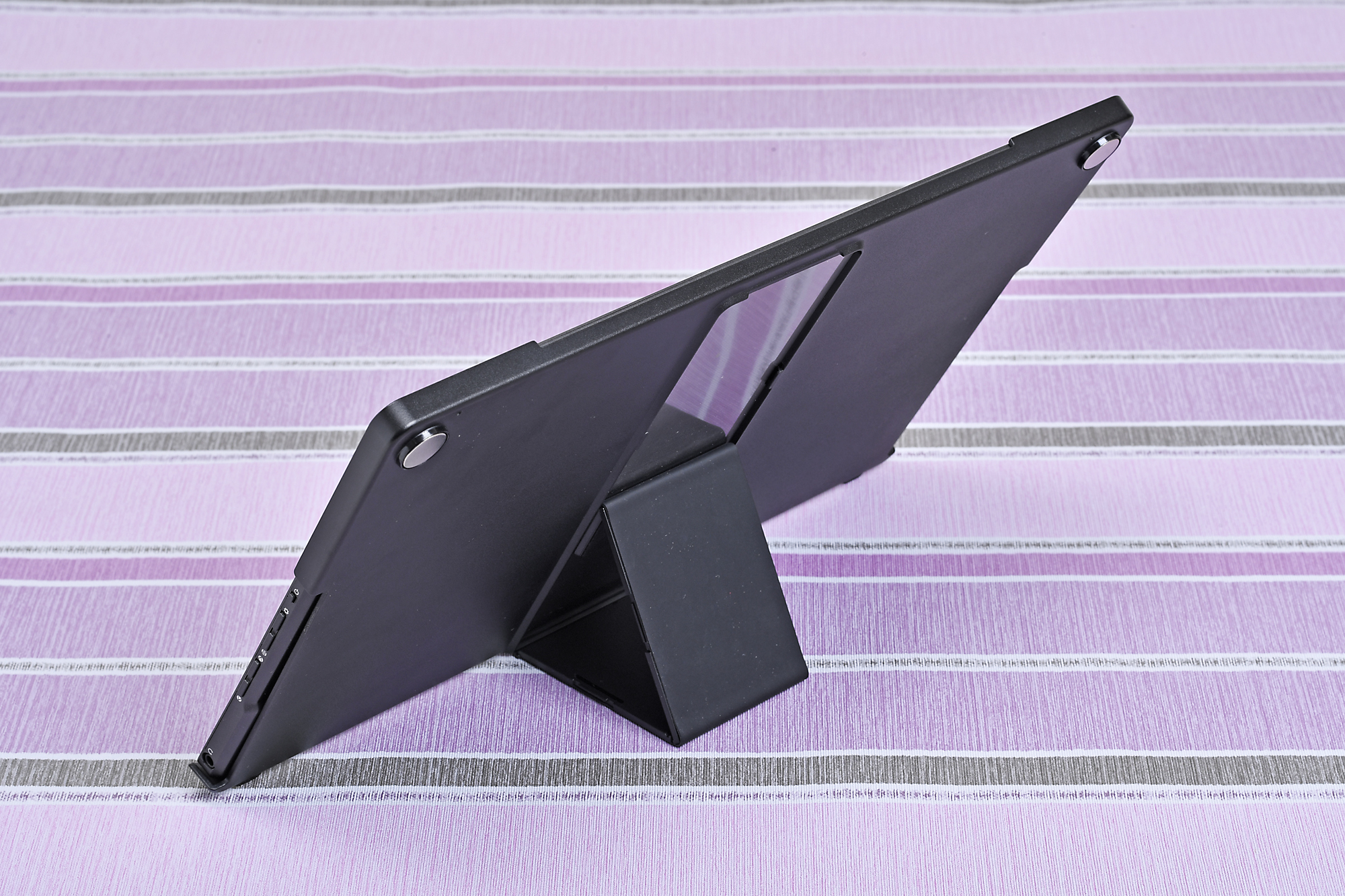 カバーの背面側に三角形にして安定感を高めるスタンドを装備する