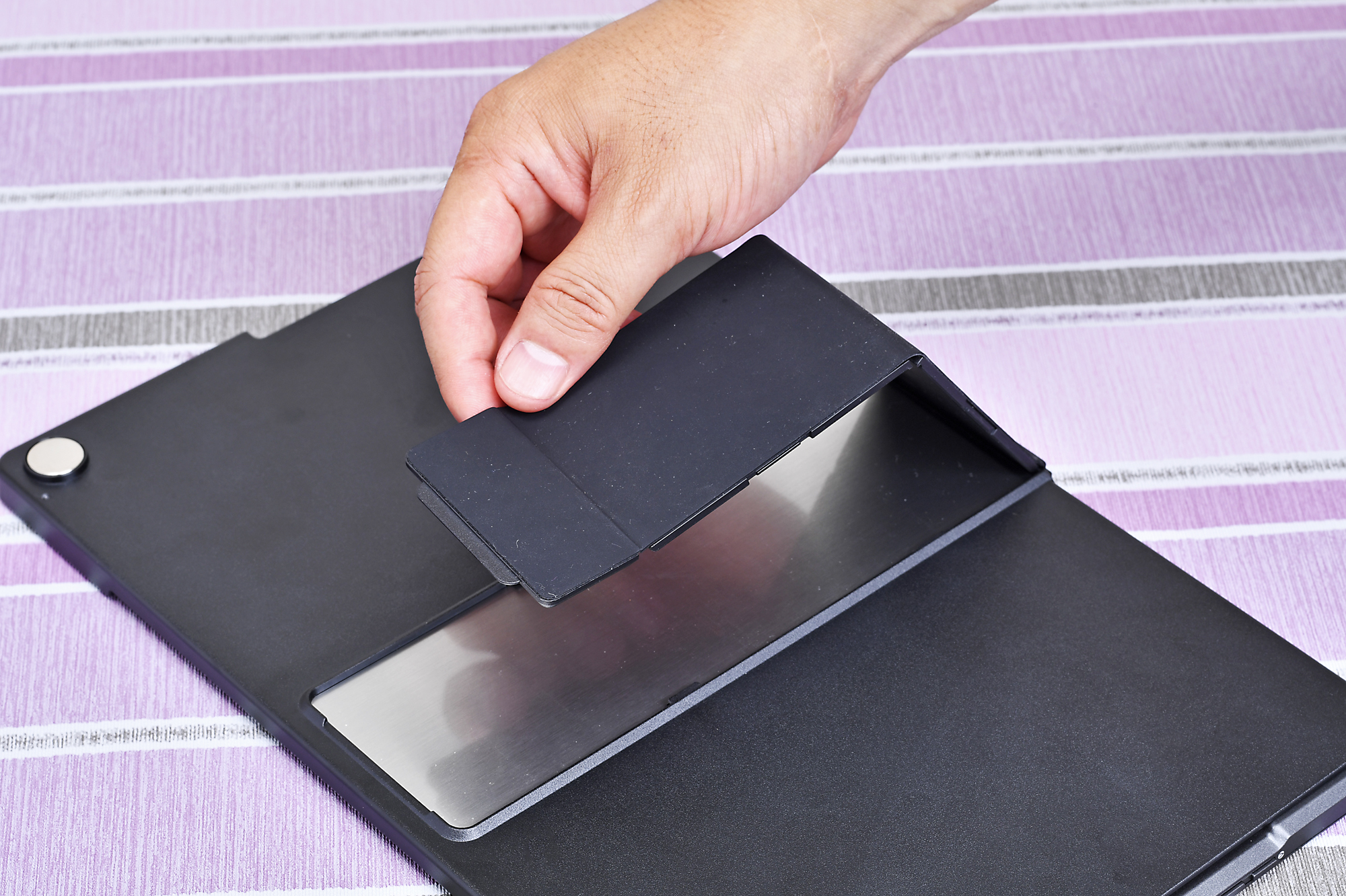 カバーの背面側に三角形にして安定感を高めるスタンドを装備する