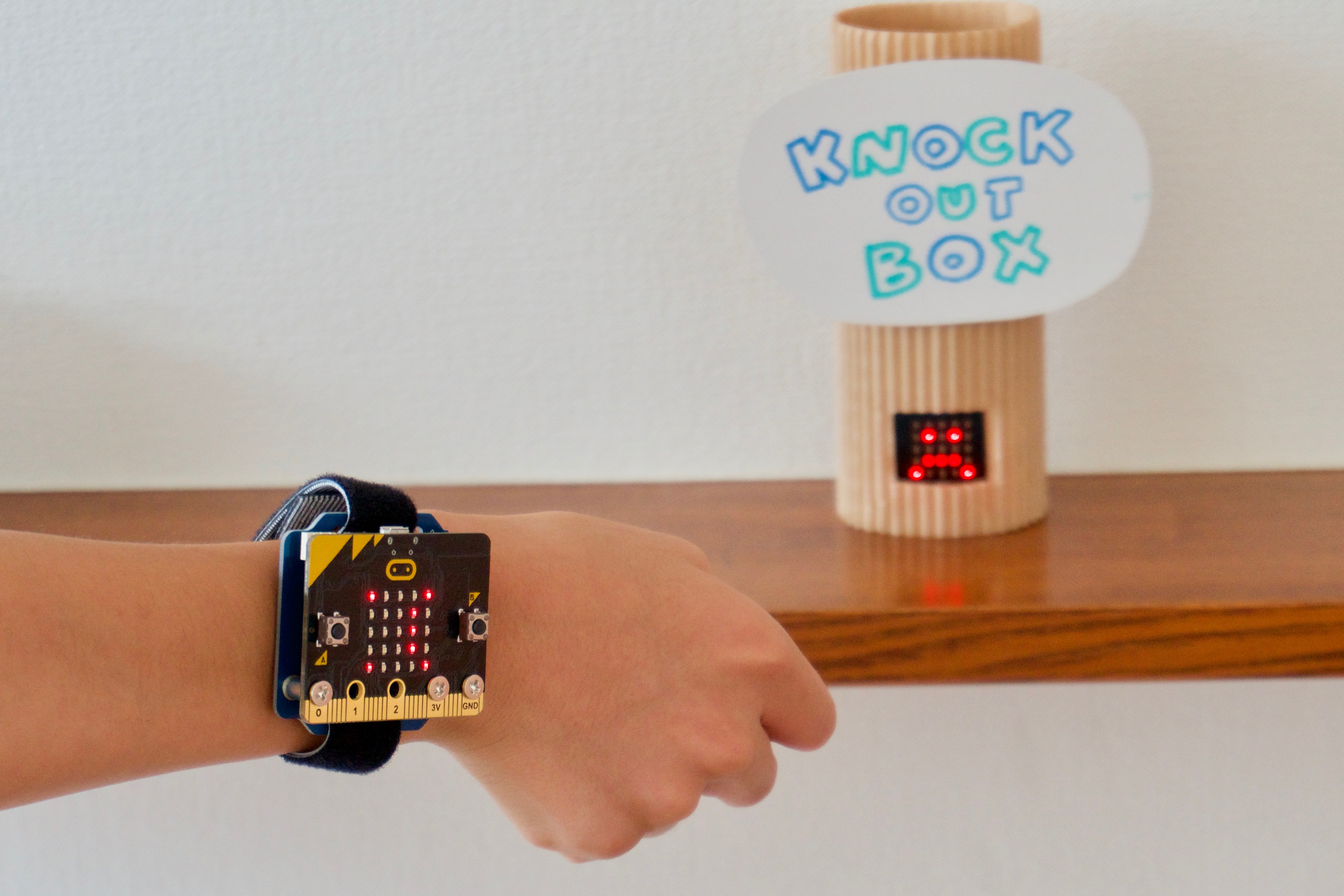 筆者が作成した「micro:bit」を2つ使った例。「micro:bit」をはめた腕でパンチをすると、パンチスピードに応じて、紙筒に仕込んだ方の「micro:bit」が反応して顔アイコンが出る