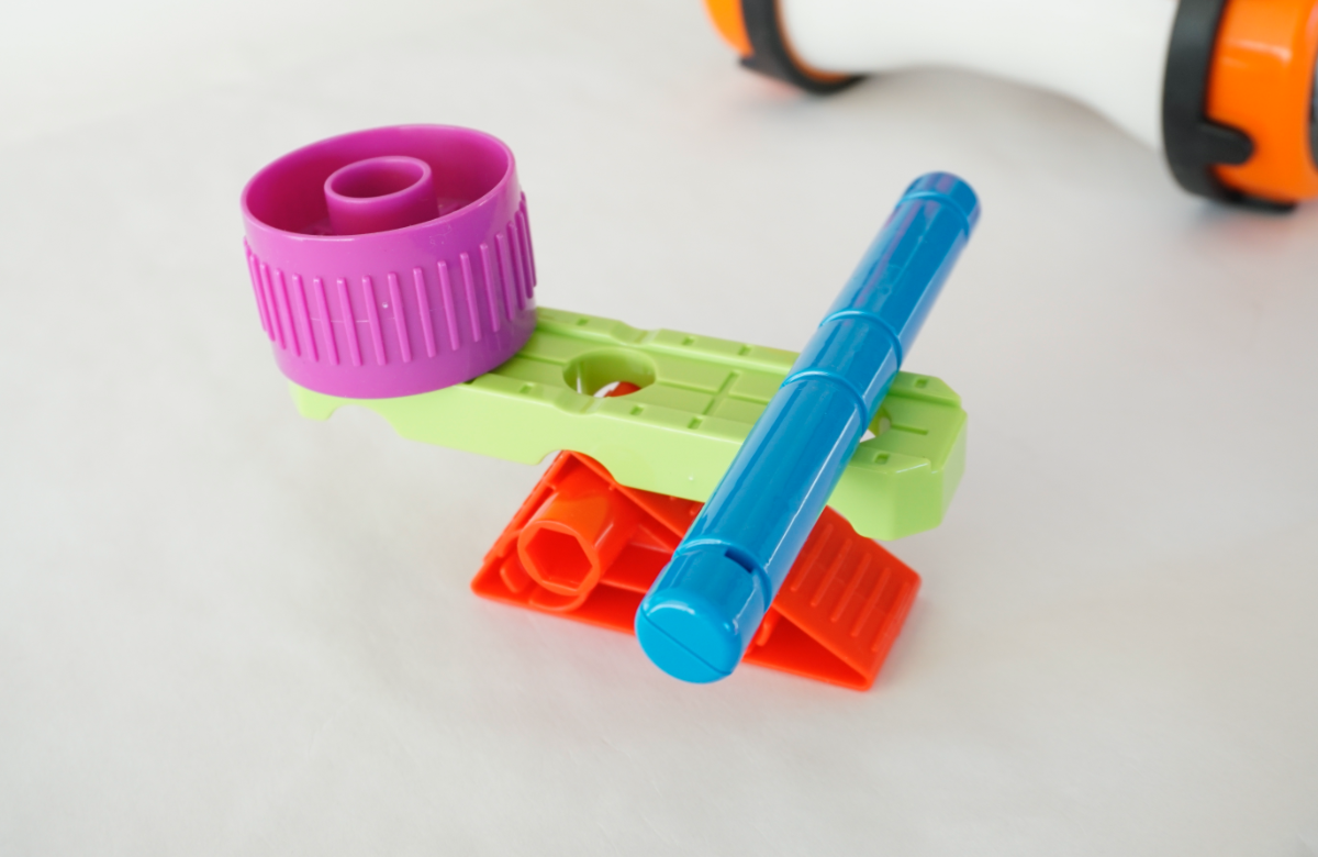 赤と黄緑のパーツでシーソーの形にしてバランスをとったり、傾斜を作って紫のパーツを転がしたりして、力学を実感