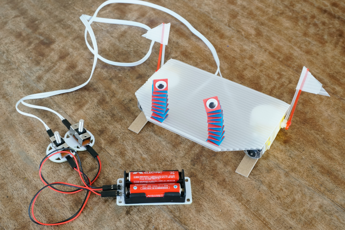 段ボールで足をつけて、裏返して完成。色紙でバネを作ってキット付属の目玉をつけた