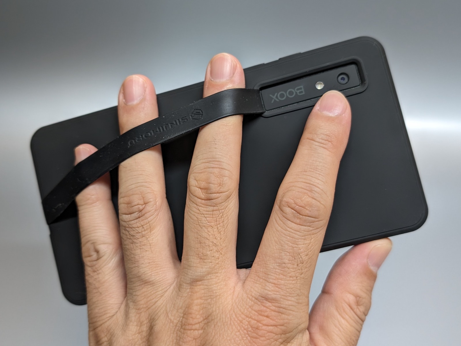 オプションの保護ケースを取り付け、さらにサードパーティ製のシリコンバンドを取り付けた状態。これならば握らなくても保持できる