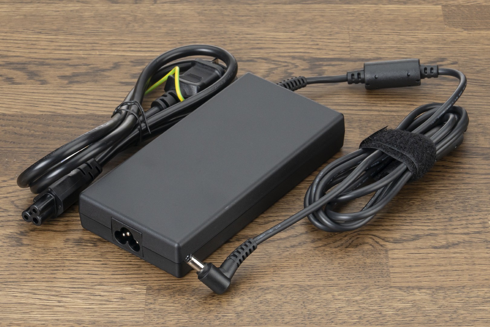 「<a href="https://www.mouse-jp.co.jp/store/g/gdaiv-n6i9g80bkcfdw101dec/?utm_source=mdmr&utm_medium=content-text&utm_campaign=2509_mdnm_ai&utm_content=pr" class="strong nb" target="_blank">DAIV N6-I9G80BK-C</a>」のACアダプタ。高性能なノートPCはACアダプタも大きくなるが、この製品でスリムな形状で持ち運びにも配慮されている