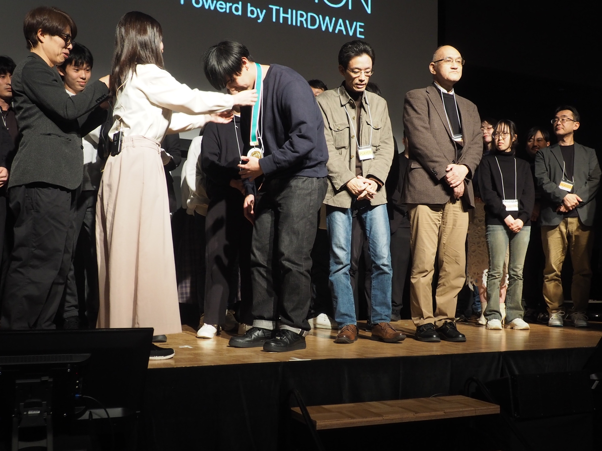 千代田まどかさんが優勝した「たい焼きテクノロジーズ」のメンバーの首にメダルをかけた