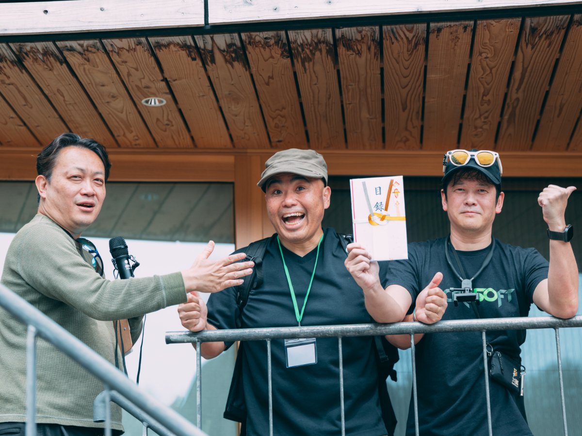 優勝賞金の目録を手に喜ぶ「AIもいっしょ」チームメンバー（撮影: g.O.R.i）