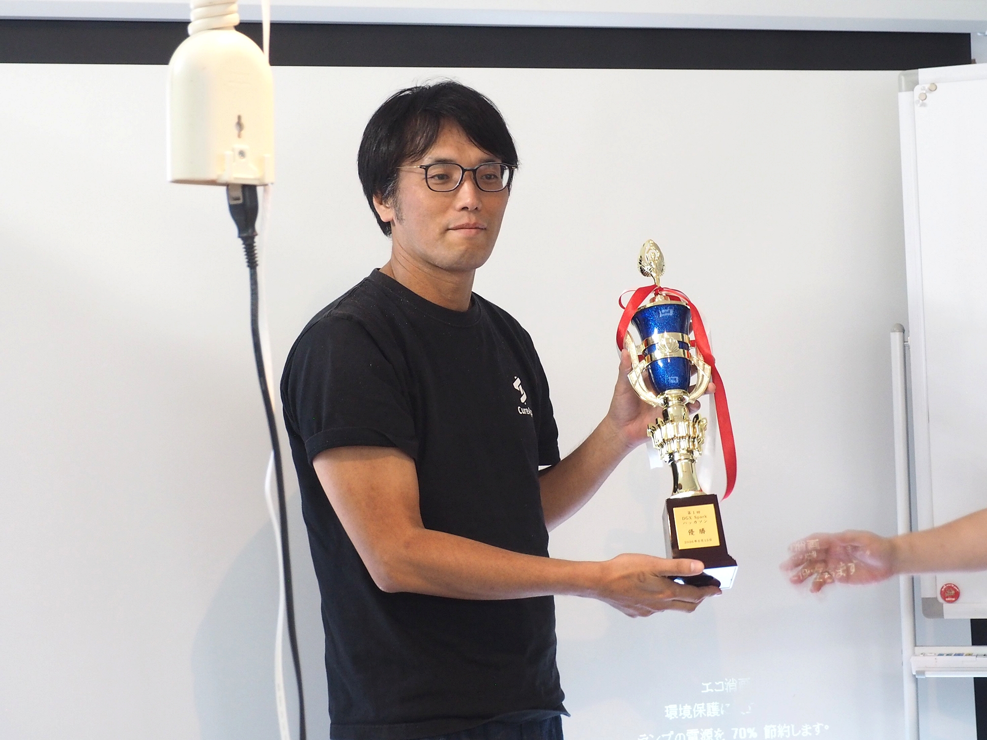 「第一回DGX Sparkハッカソン」の優勝者・宋龍平氏に優勝トロフィーが贈呈された