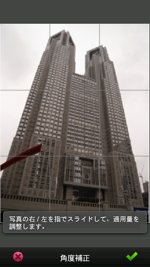 “角度補正”編集中。補助線を参考に画面の左側や右側を上下にドラッグすることで、画像を少しずつ回転できる