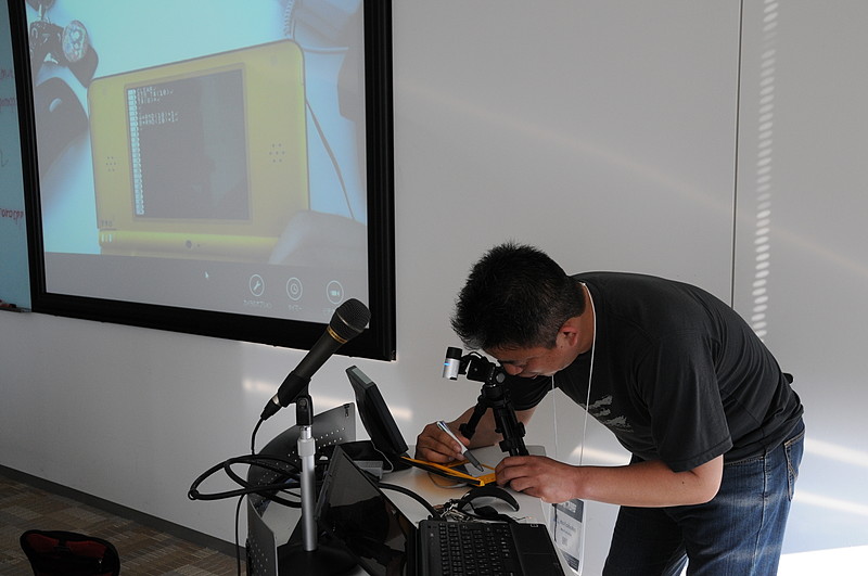 即興でプログラミングを開始。1分もしないうちに弱音を吐きながら画面中を歩き回るキャラや“イェイ”“チェキラッ”などと合いの手を入れるシーケンサなどを作成