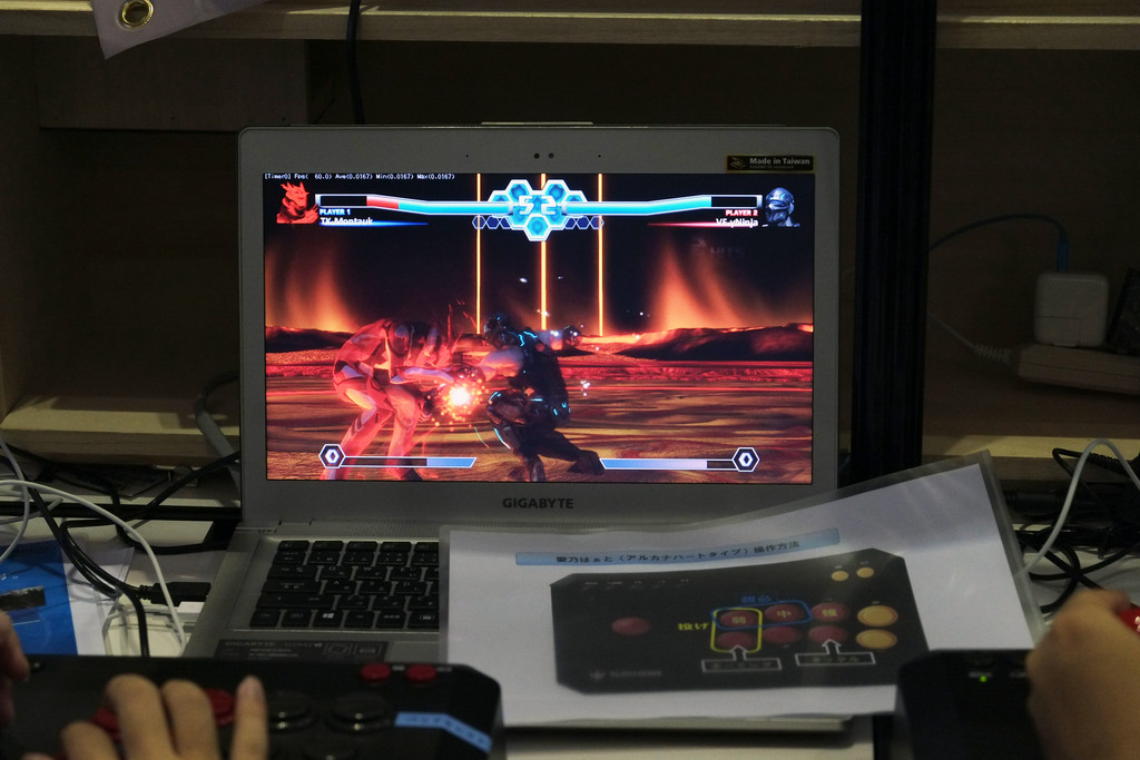 ユーザー応募キャラクター“Montauk”（左）と“yNinja”（右）のバトル。ステージもユーザー応募によるもので、火山地帯のような“Lava_pahoehoe”ステージ。対戦用にアーケード型のジョイスティックが用意されていた