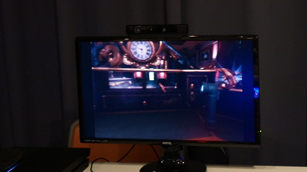 机の影に隠れている……