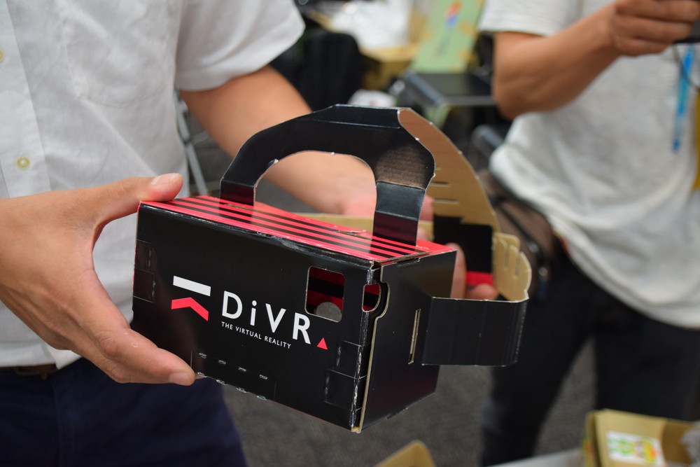 電脳かふぇのブースで展示されていた、ヘッドバンド付きで手を放せるスマホ向けVRデバイス“DiVR”。さまざまな大きさのスマホを装着できる