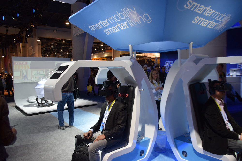 デンソーのOculus Rift DK2での展示。トラッキングカメラを組み込むため前方まで突き出す近未来的な構造になっている。