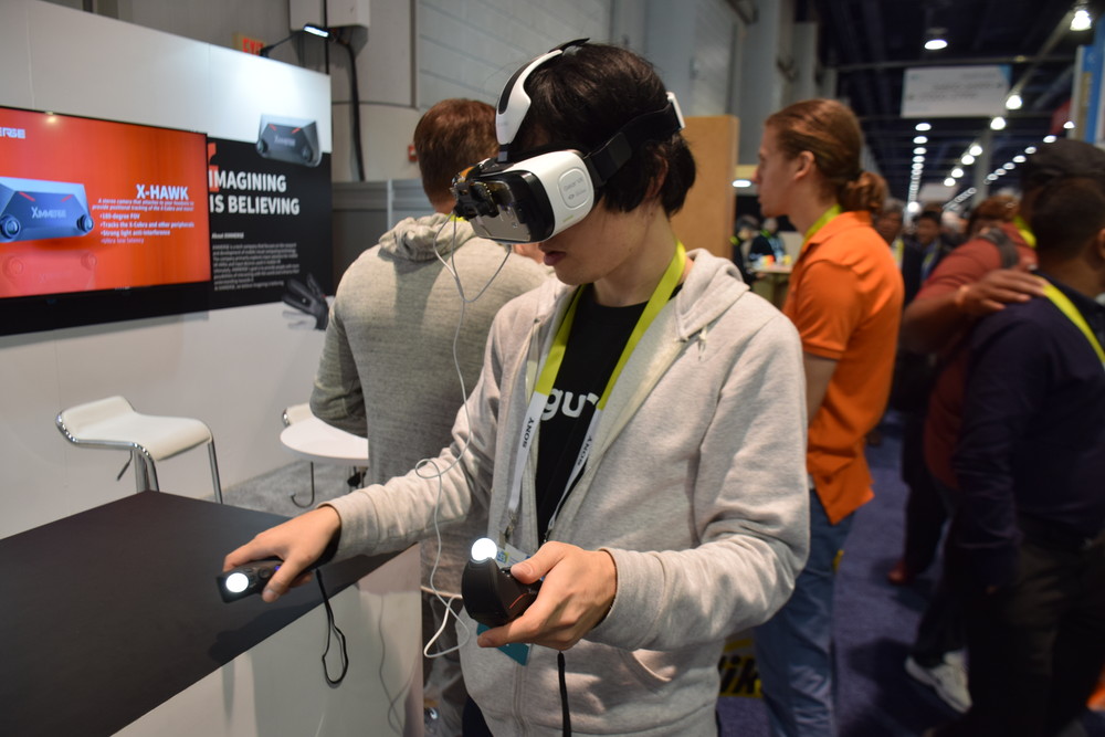 Gear VRやモバイルVRヘッドセット向けの“Ximmerse”。ステレオカメラをGear VRに装着し、棒状のコントローラーと組み合わせて手の位置とプレイヤーの位置を検出する。操作性はかなり良好だ
